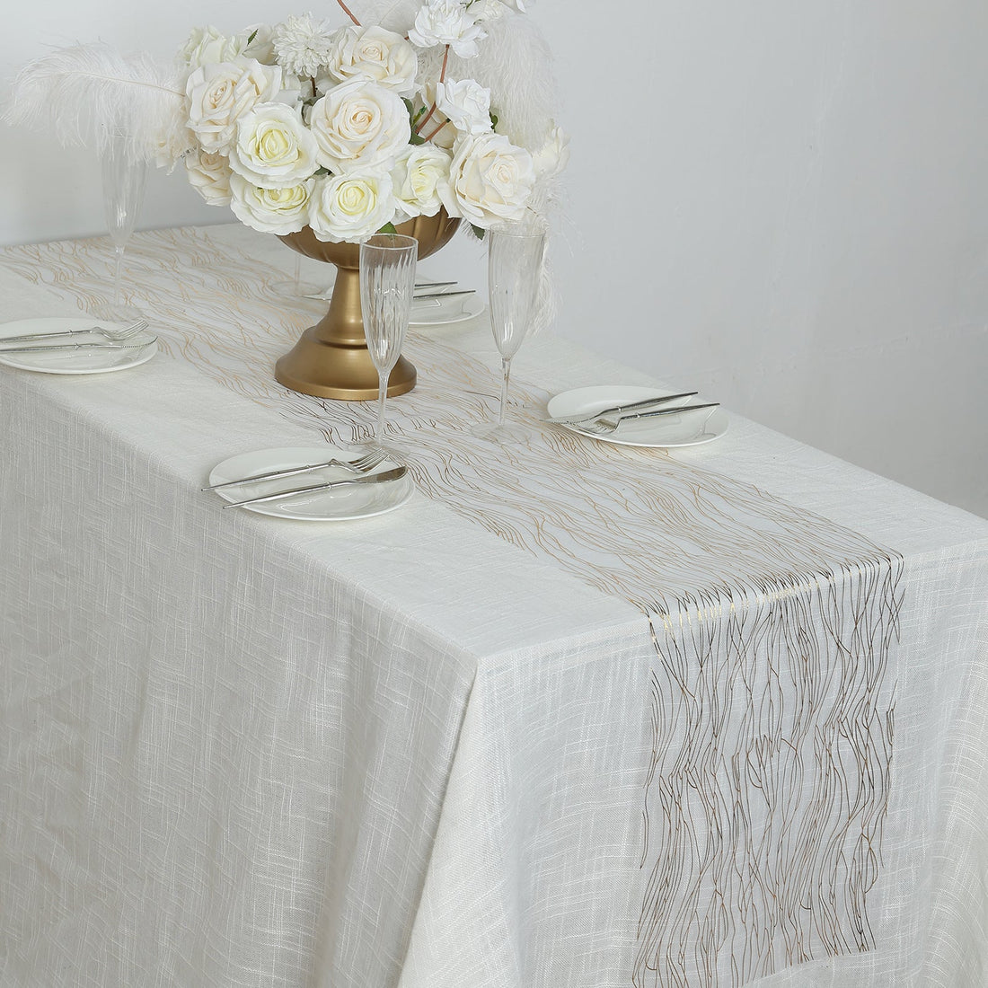 Elegant table setting with floral centerpiece and decorative table runner.