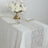 Elegant table setting with floral centerpiece and decorative table runner.