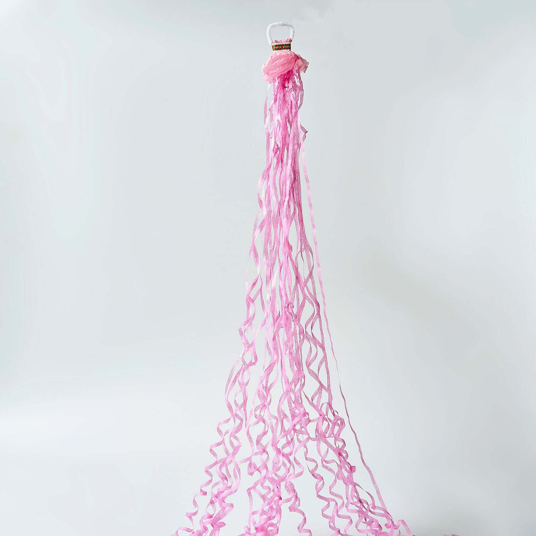 Pink curling ribbon rolls with long strands draping down.