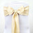 Elegant cream chair sash with pearl embellishment, perfect for weddings or events. 
