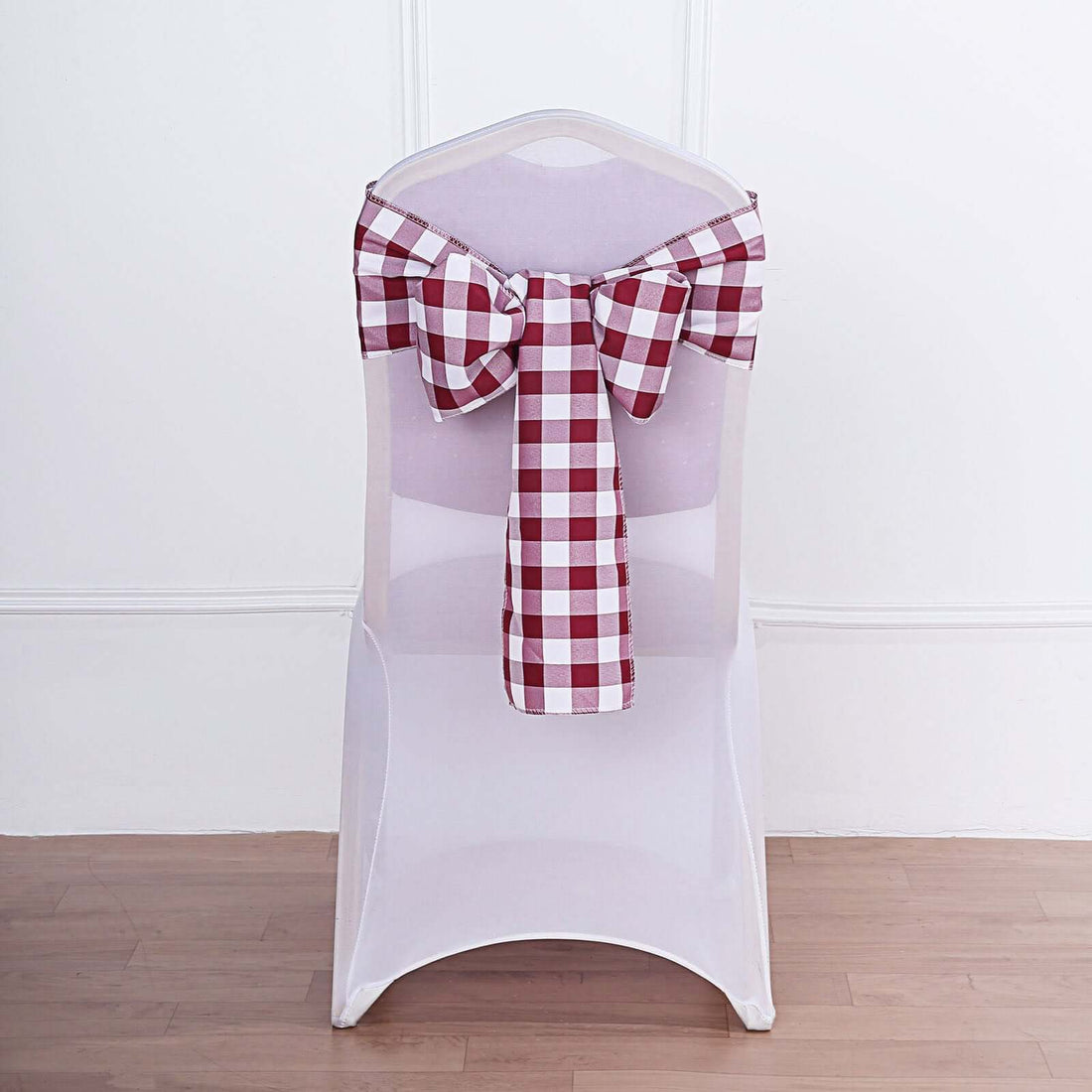 Transparent chair cover with red and white checkered bow