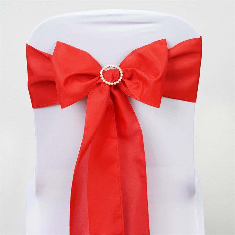 Red satin chair sash with a pearl embellishment.