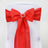 Red satin chair sash with a pearl embellishment.
