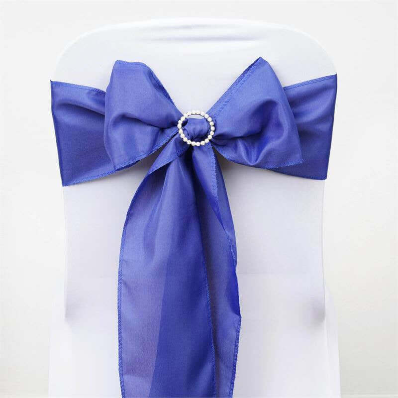 Blue satin chair bow with pearl embellishment on a white chair. #whtbkgd