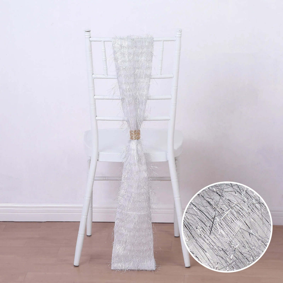 Silver chair sash with textured design draped over a white chair.