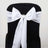 White satin chair sash with bow and rhinestone detail on black chair.