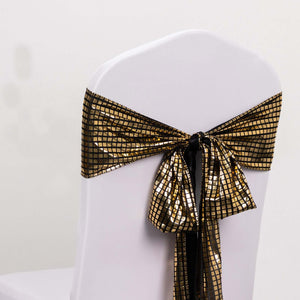 Gold and black sequin chair sash tied on a white chair.