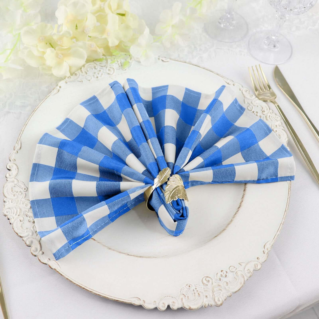 Blue and white checkered napkin elegantly folded on a decorative plate.