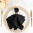 Elegant black napkin with butterfly napkin ring on dining plate setting.