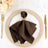 Elegant brown napkin with butterfly holder on a decorative dinner plate.