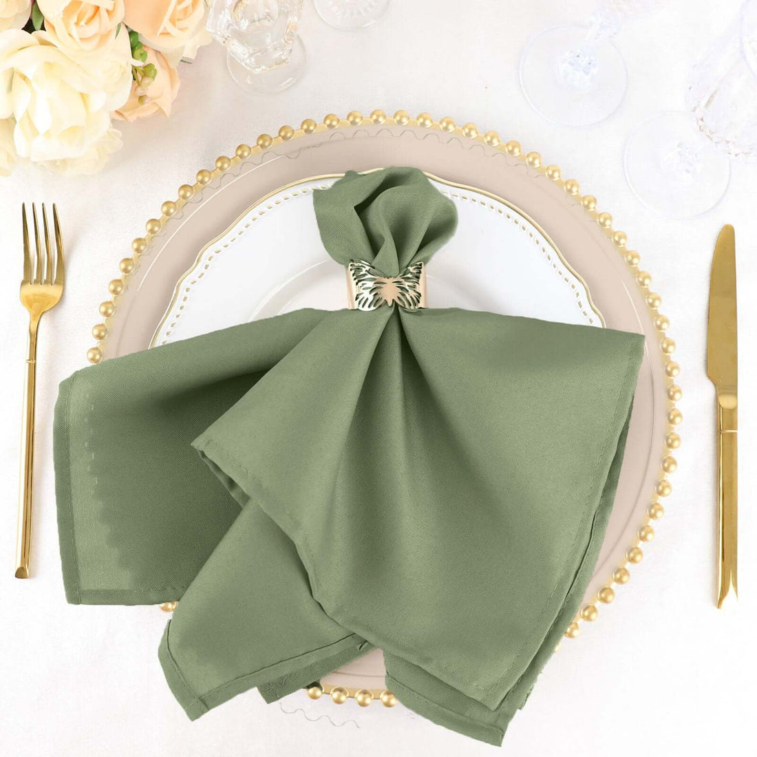 Elegant olive green napkin styled on a decorative plate with gold accents.