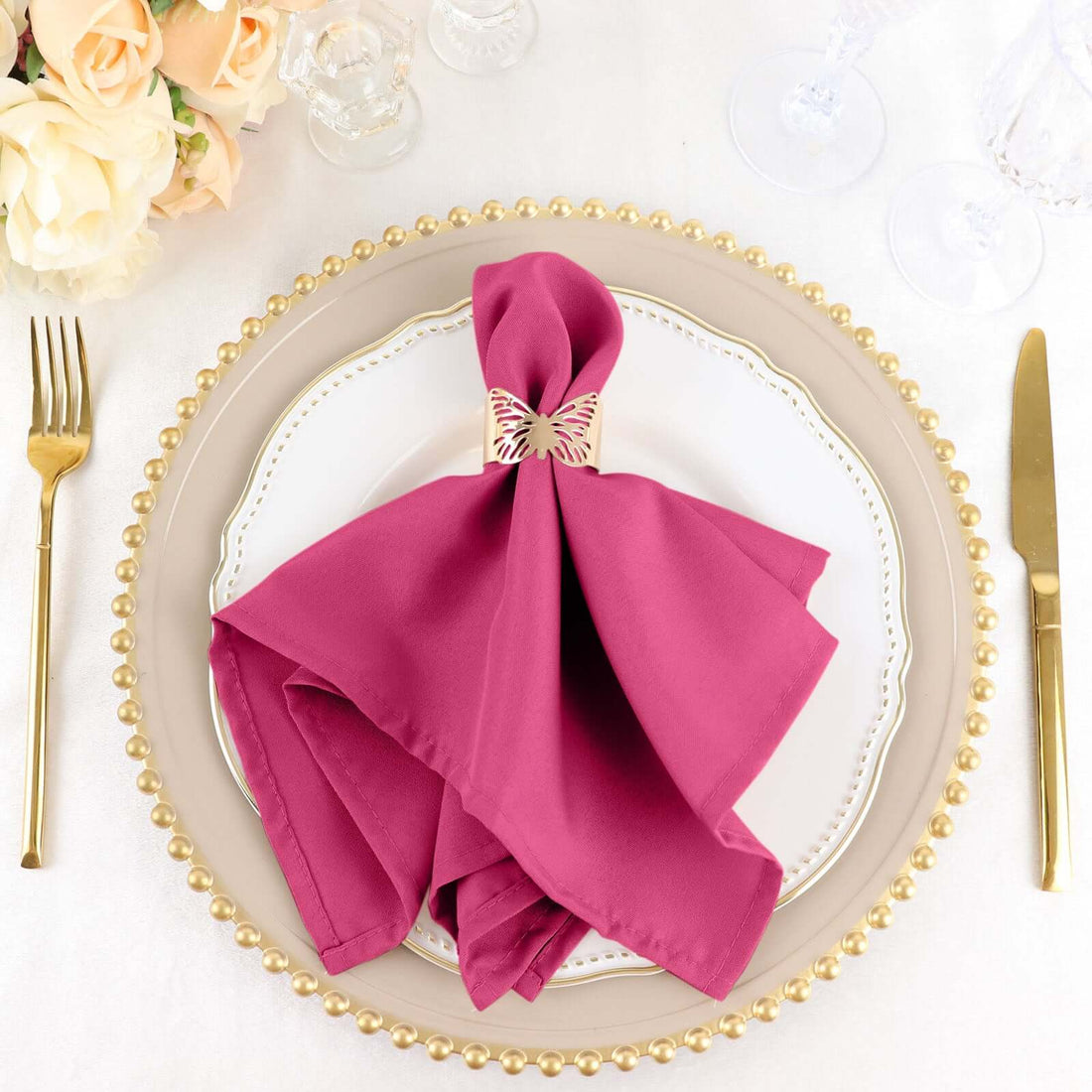 Elegant magenta napkin with decorative ring on a decorative plate setting.