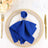 Blue napkin with a butterfly ring on an elegant dining plate.