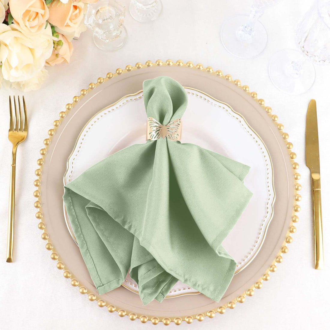 Elegant green napkin on a decorative plate set for dining.