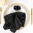 Black napkin with butterfly napkin ring on a decorative plate.