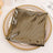 Black grid-patterned placemat on a decorative gold-rimmed plate.
