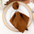 Brown napkin with silver ring on an elegant dinner plate.