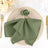 Elegant green napkin styled with a decorative ring on a chic dinner plate.
