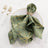 Green patterned napkin elegantly styled on a decorative plate with cutlery.