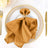 Elegant gold napkin with butterfly ring on a decorative plate.