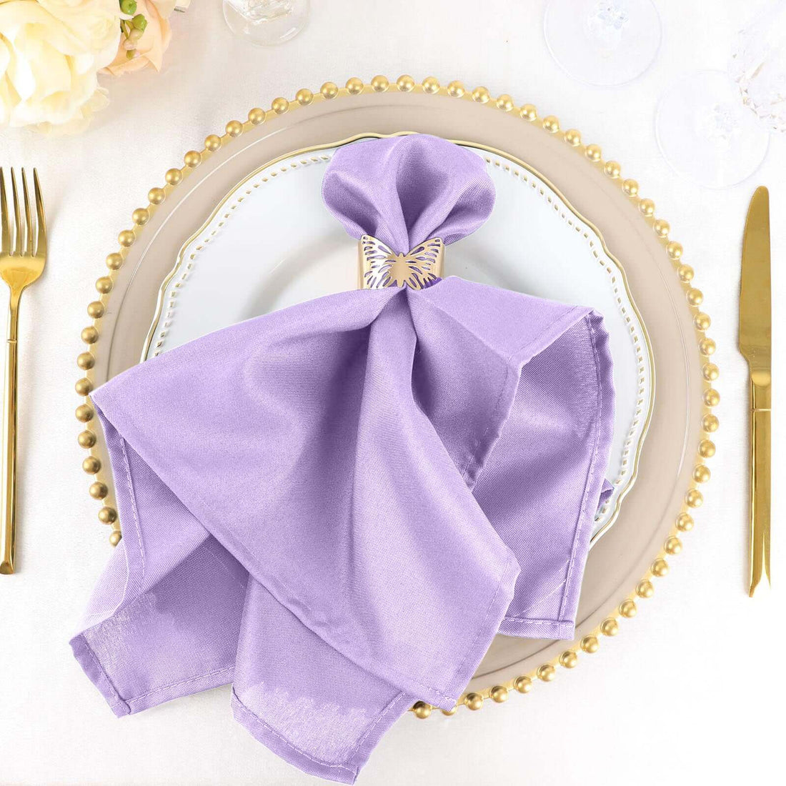 Lavender napkin elegantly arranged on a decorative plate with gold accents.