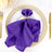 Purple napkin elegantly arranged with a butterfly napkin ring on a plate.