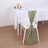 Green chair sash tied on a white chair at a dining table setting.