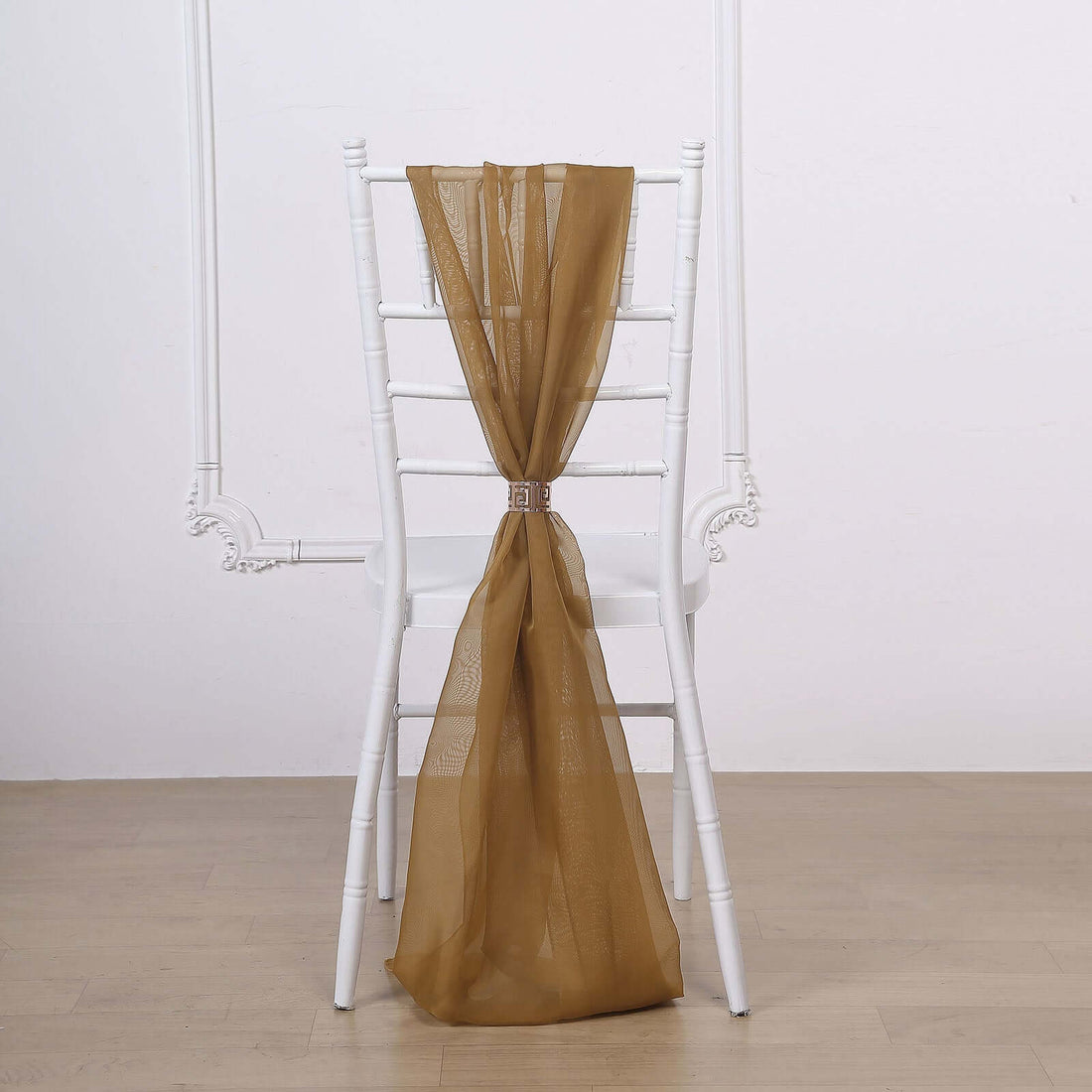 Brown sheer chair sash draped elegantly over a white chair.