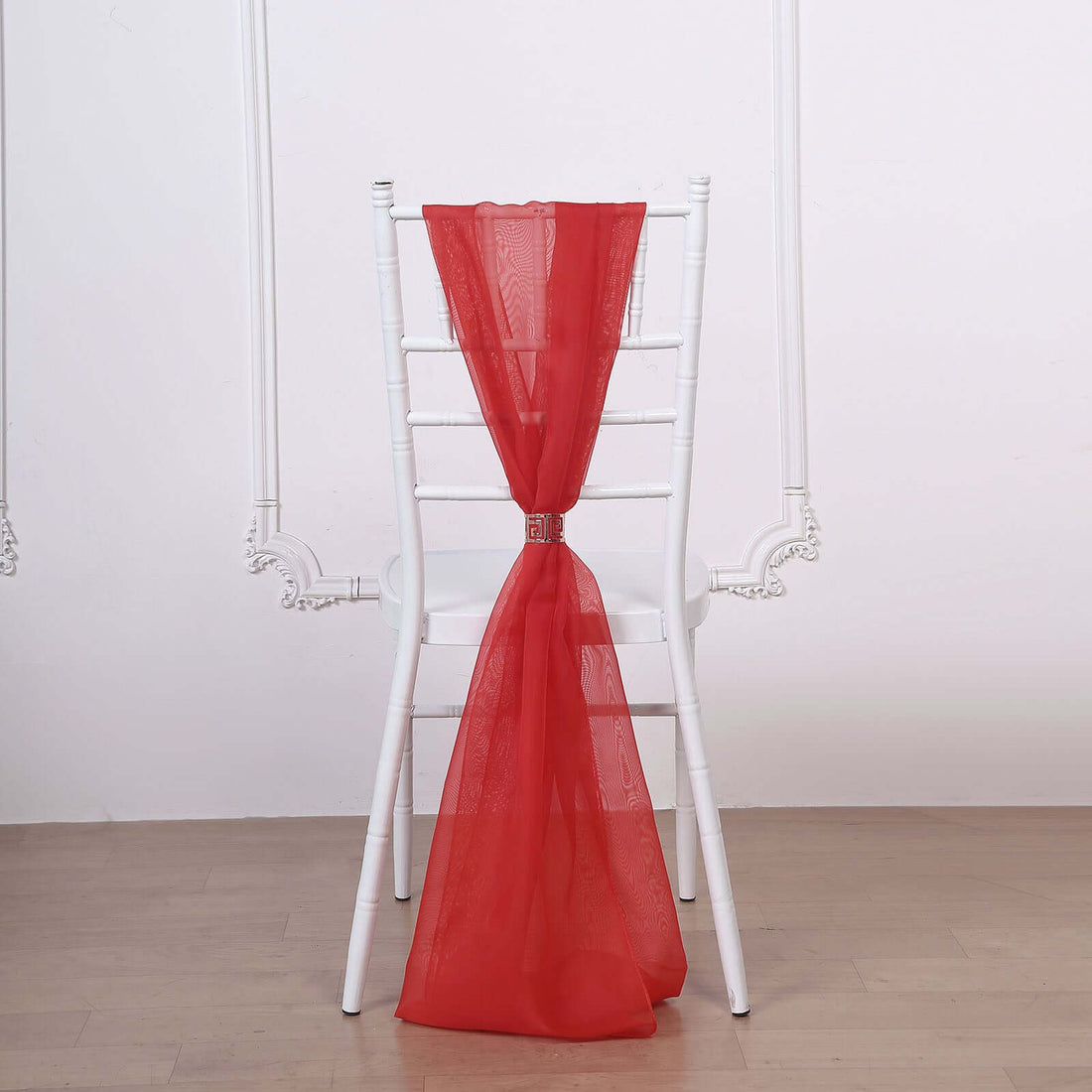 Red sheer chair sash draped elegantly on a white chair.
