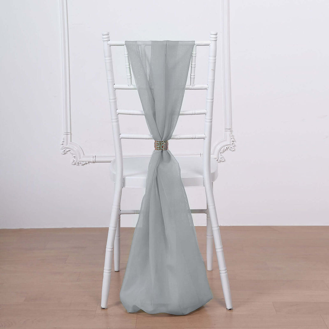 Gray sheer chair sash draped elegantly on a white chiavari chair.