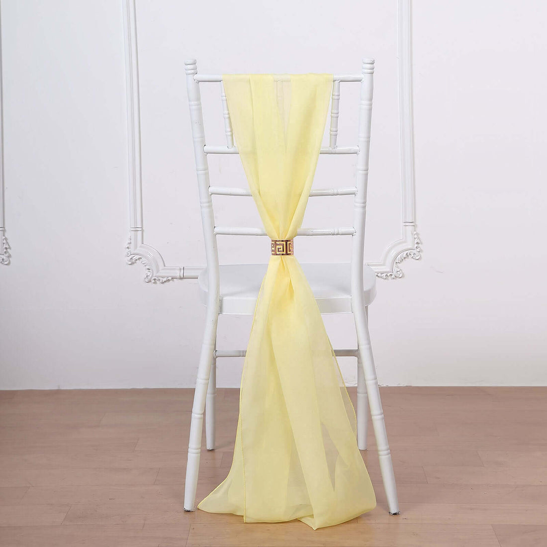 Yellow chiffon chair sash draped elegantly on a white chair.