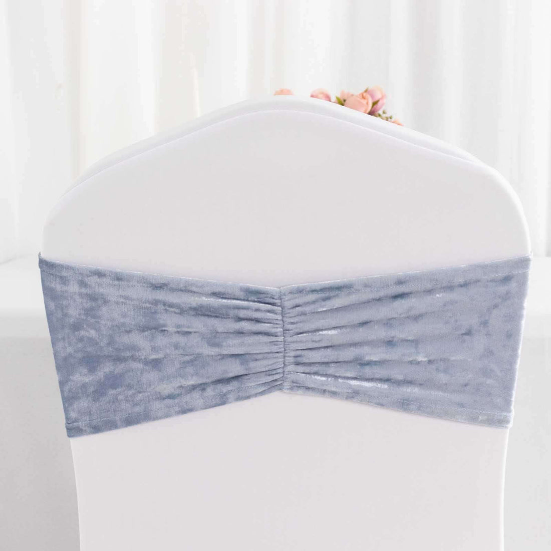 Gray velvet chair cover with gathered design on a white chair.