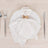 Elegant white napkin with butterfly holder on a decorative plate.