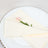 Elegant cream napkin with a pink flower on a decorative plate.