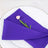 Purple napkin elegantly folded on a white plate with a pink flower accent.