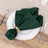 Green napkin elegantly tied with a decorative ring on a decorative plate.