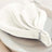 Elegant white napkin elegantly folded on a plate with decorative beads.