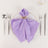 Lavender napkin elegantly folded with a gold ring on a dinner plate