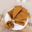 Elegant gold napkins styled on a white plate for dining decor.