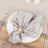 Elegant silver napkin tied with a decorative ring on a decorative plate.