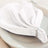 Elegant white napkin with decorative beading on a plate.
