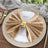 Elegant gold napkin holder with luxurious beige napkin on a dinner plate.