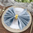 Elegant blue velvet napkin with gold ring on a decorative plate.