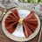 Rustic brown napkin with a gold ring on an elegant plate setting