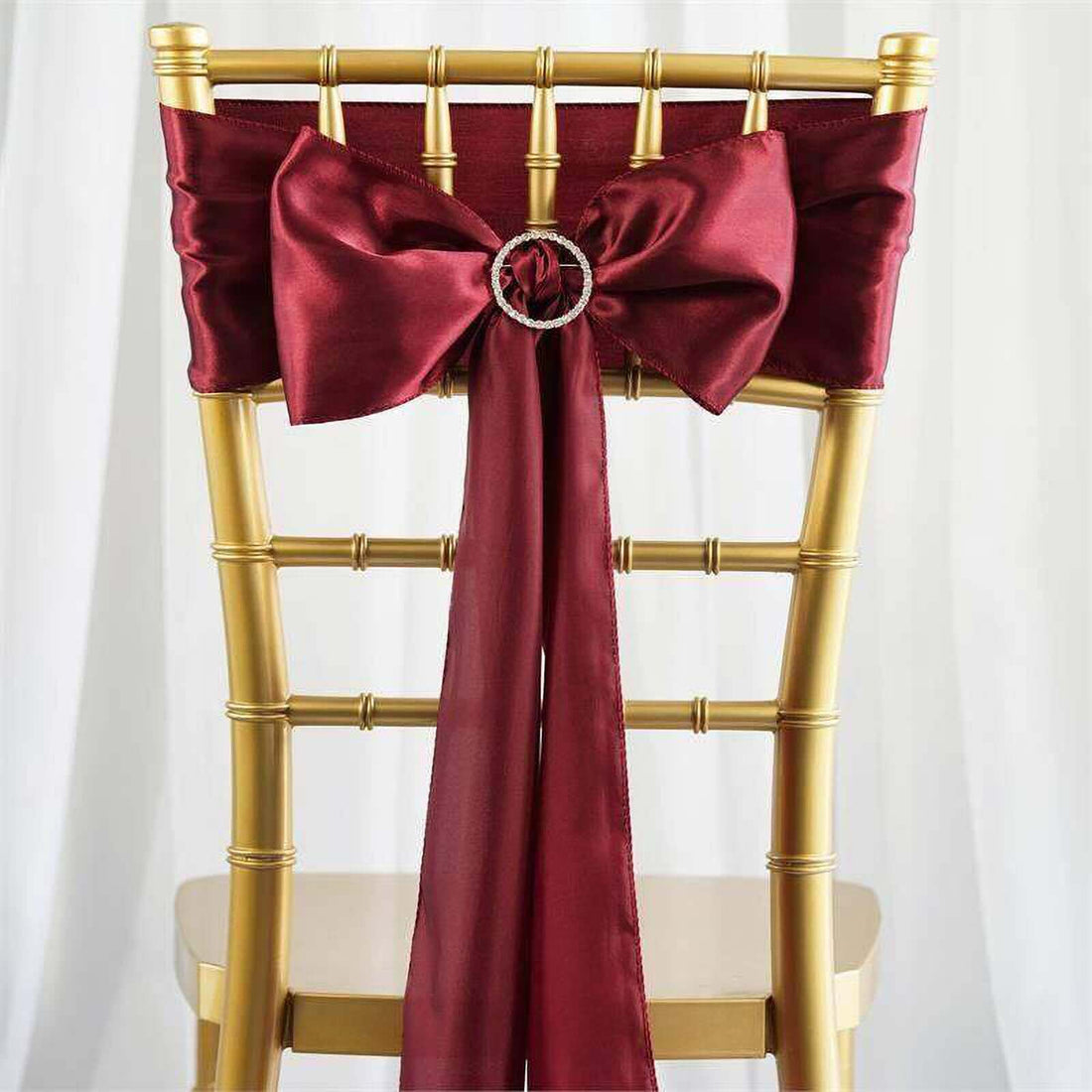 Burgundy satin chair sash with bow and decorative ring