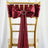 Burgundy satin chair sash with bow and decorative ring
