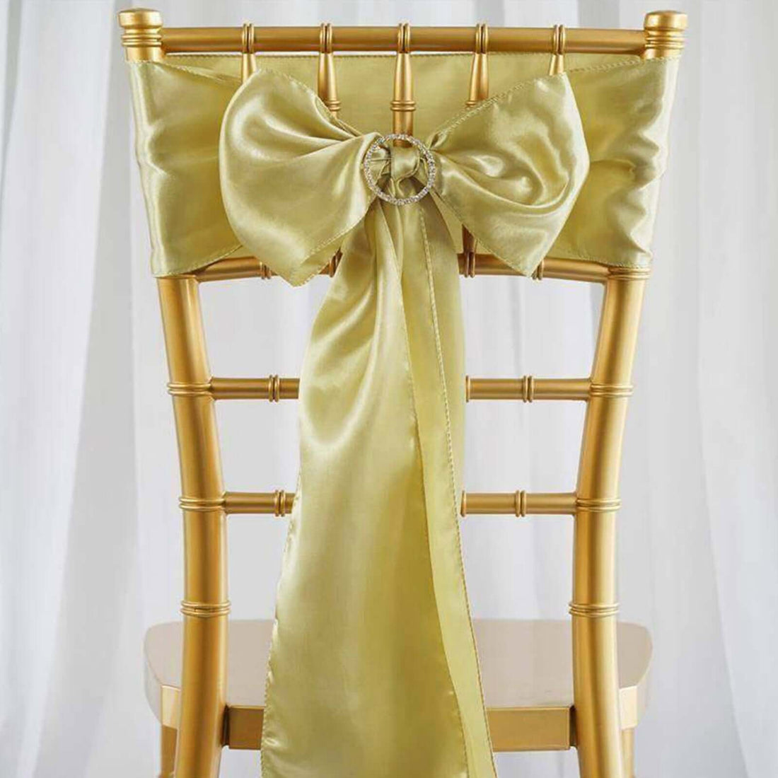 Gold chiavari chair with a yellow satin bow and ribbon decoration.