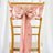 Gold chiavari chair with a pink satin bow and rhinestone detail.