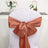 Copper satin chair sash tied in a decorative bow.