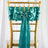 Teal satin chair bow with a rhinestone ring on a gold chiavari chair.